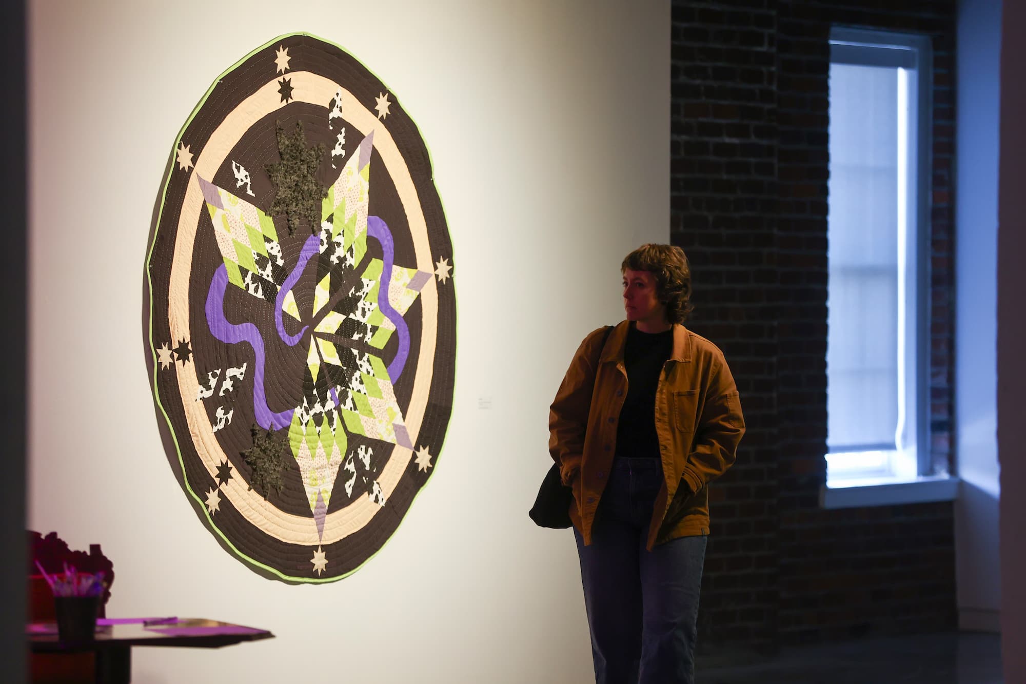 person walking by art on gallery wall
