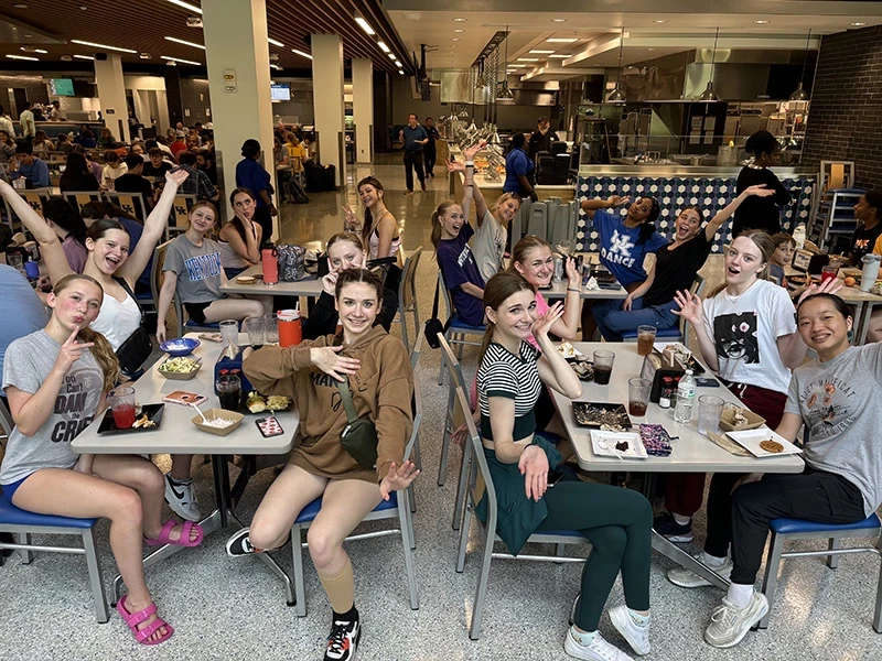 students smiling at cafeteria tables
