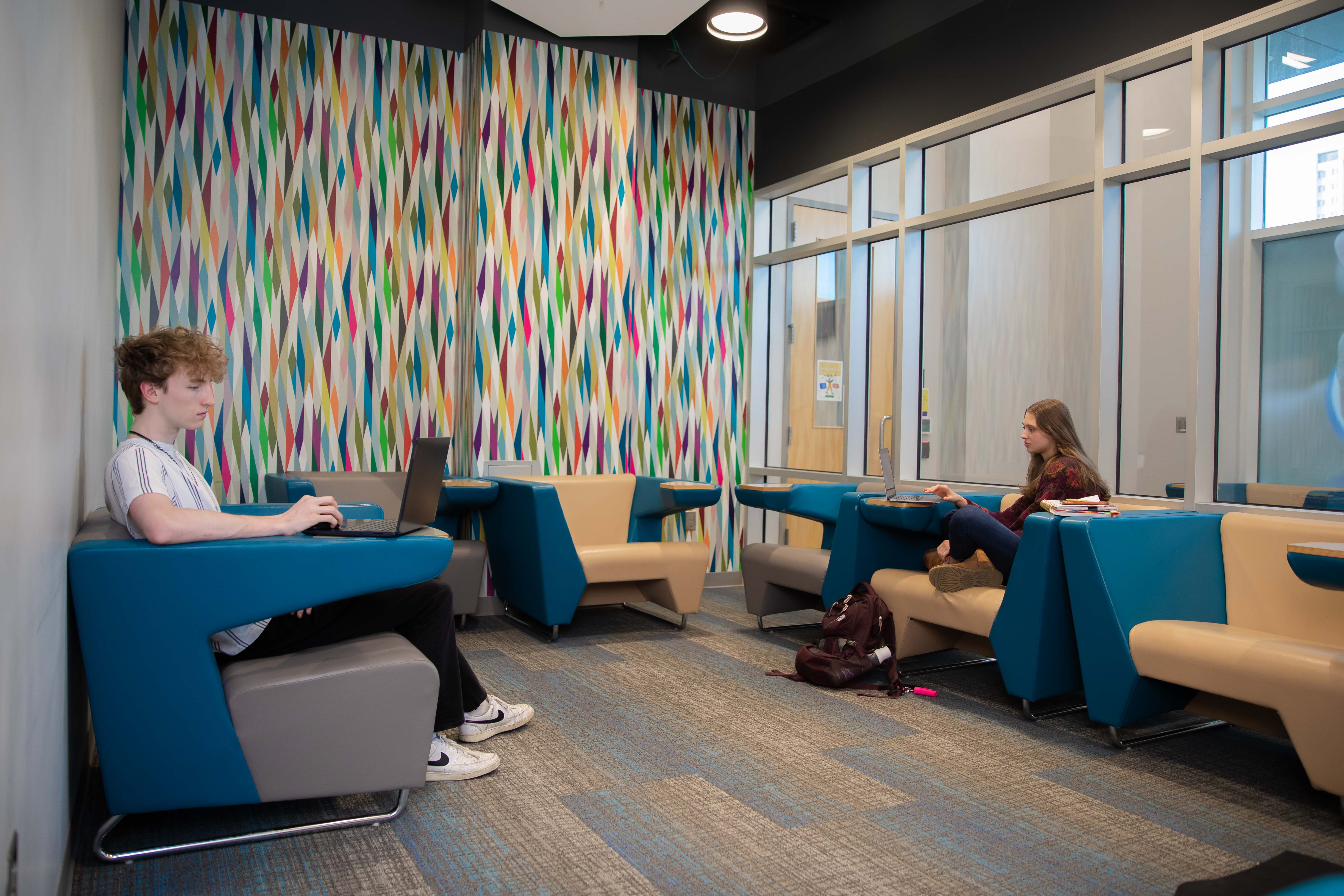 students working in room with colorful wallpaper