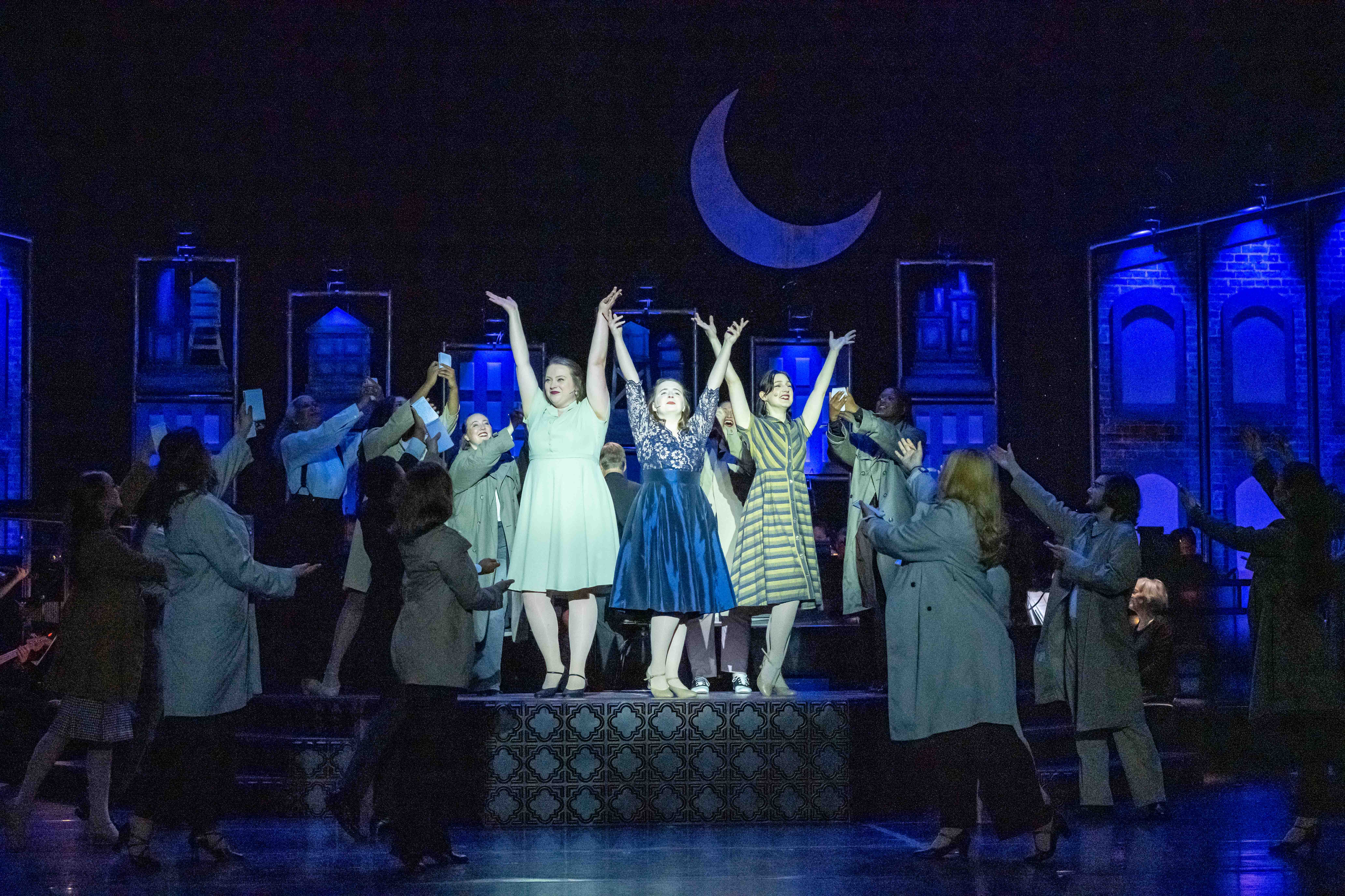 group of singers on stage, moon in scrim