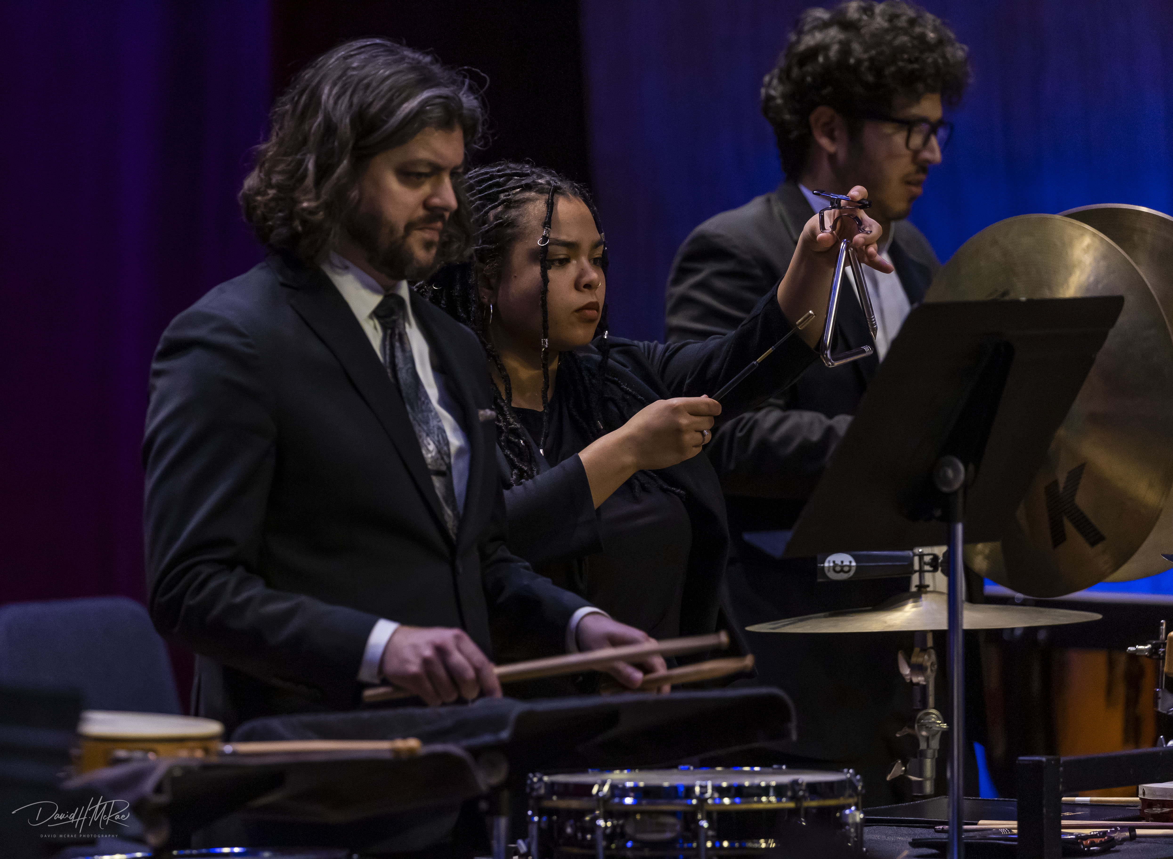 students playing percussion instruments on stage