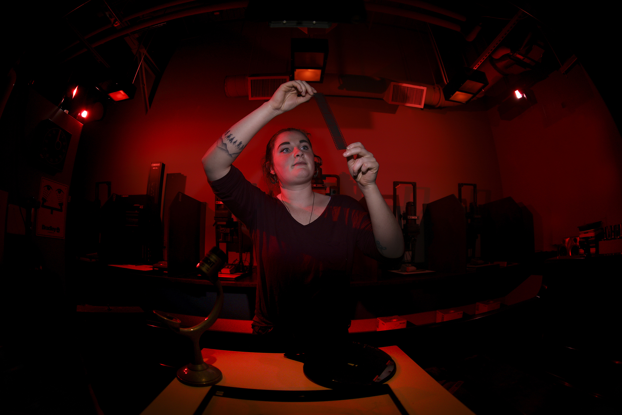 person looking at film in darkroom