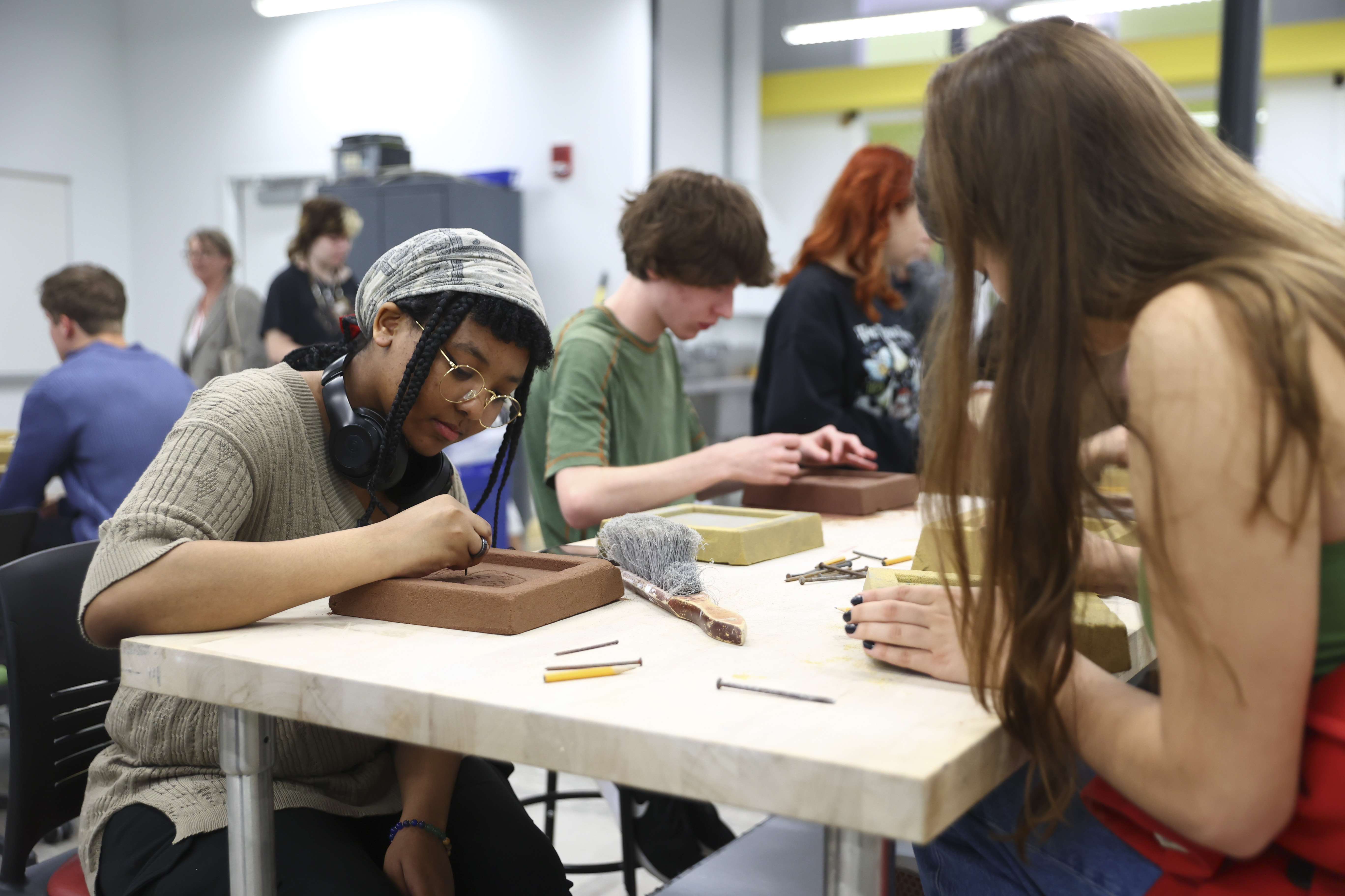 students sitting at table working on etching