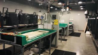 A film development lab. Many workstations are in place with small tubs, trays, faucets, saftey gear, and specialty lighting.