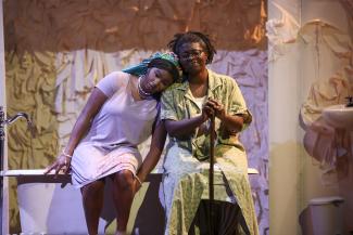 two people sitting on bathtub on stage