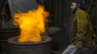 person at metal kiln with fire