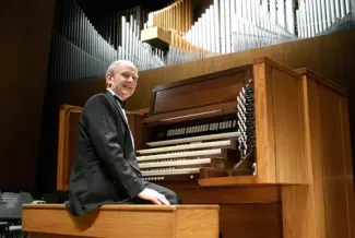 person smiling at camera sitting at organ