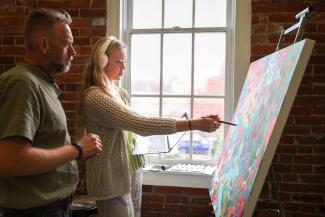 student and teacher at art easel
