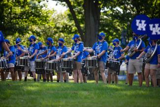 members of the marching band drumline performing outside and masked