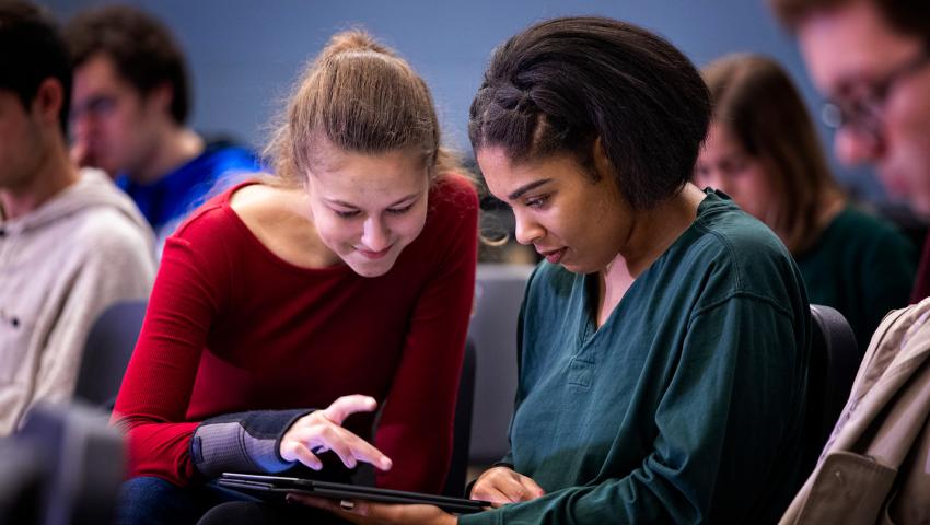 two students looking at ipad