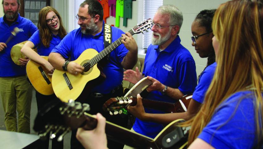 people playing instruments in music therapy class