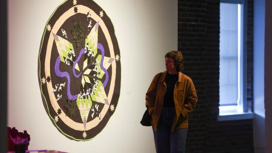 person walking by art on gallery wall