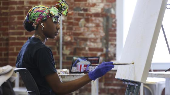 person painting on easel
