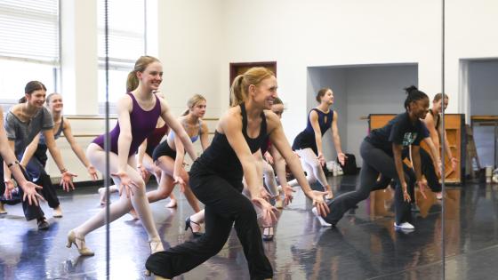 dancers posed in front of mirror smiling