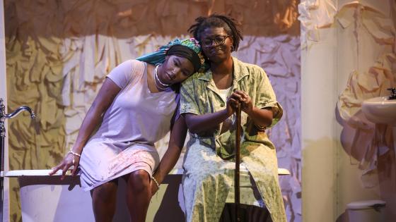 two people sitting on bathtub on stage