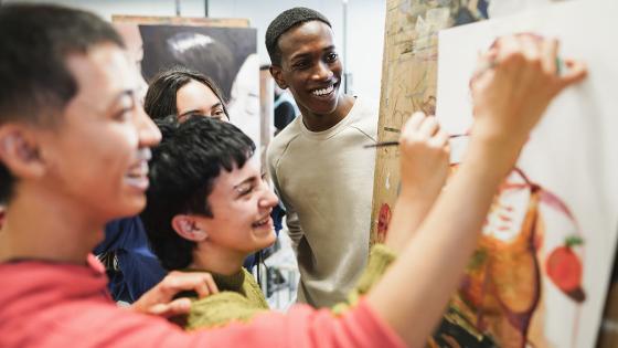 people smiling looking at art canvas