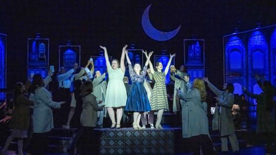 group of singers on stage, moon in scrim