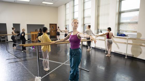 students in fifth position at barre in ballet class