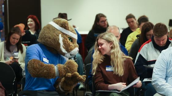 Wildcat mascot and student sitting