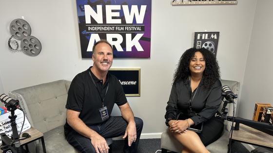 Peter Stone sitting on sofa with representative at the Newark Film Festival