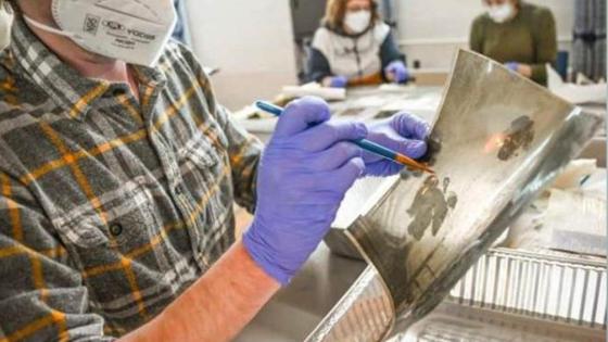 A volunteer at Hindman Settlement School helps restore a photograph following the massive Eastern Kentucky flood in July 2022. Flood waters irreparably damaged documents, photos and various works of art. Photo by Will Anderson.