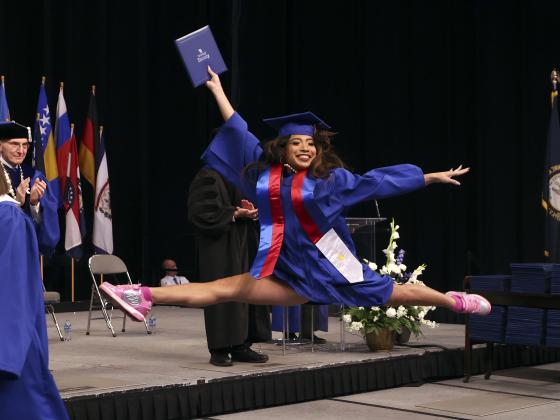 Student leaping on stage at commencement