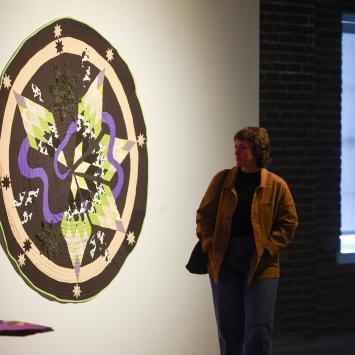 person walking by art on gallery wall