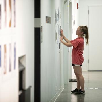 student hanging art